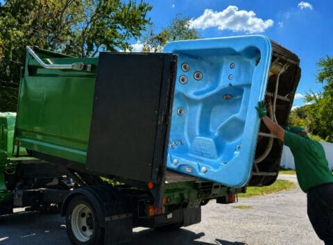 Man Loading an Old Hottub Into a Truck